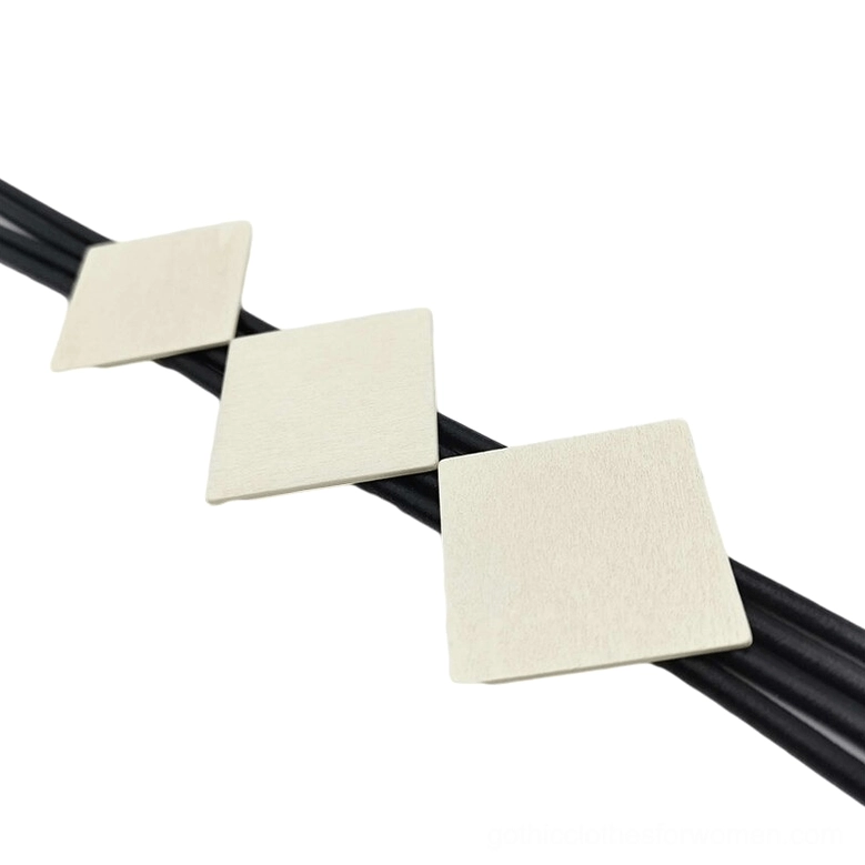 Close-up macro shot of square wood pendant necklace showing three beige square wooden charms with smooth black rubber elastic cord on white background