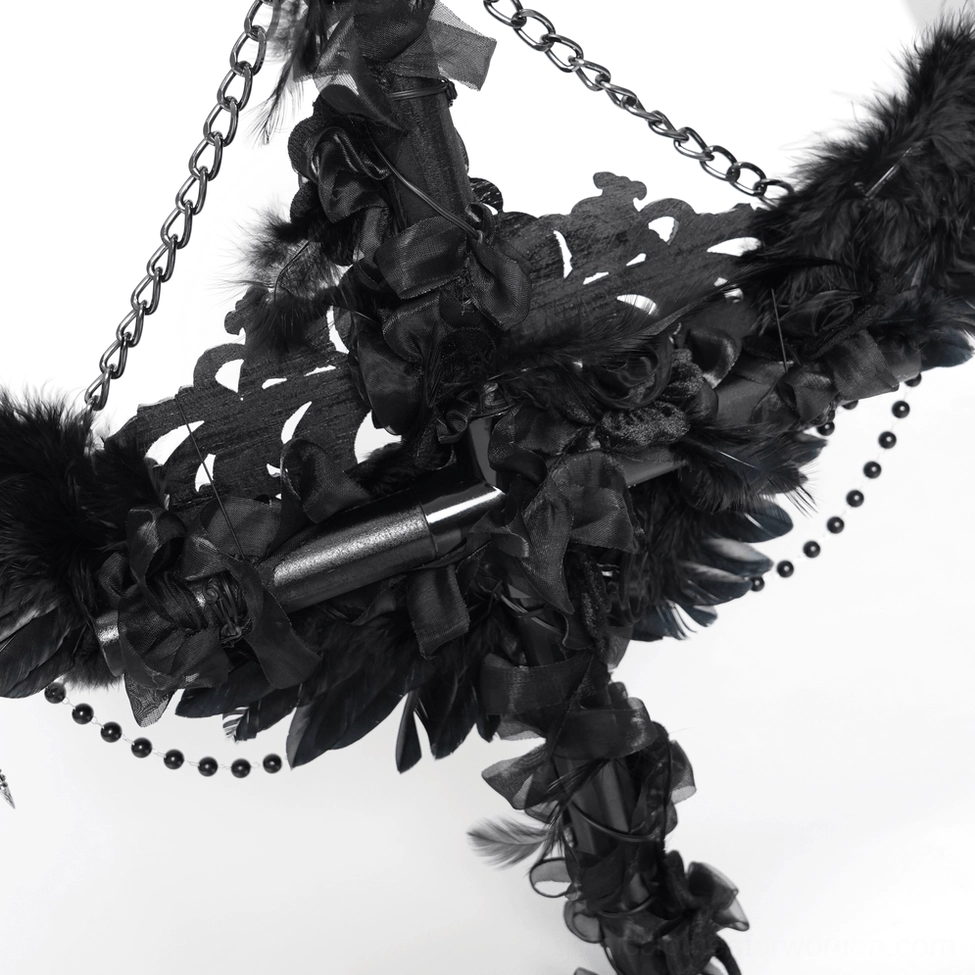 Low angle close-up of raven cross staff rear featuring black feather ruffles, metal joints and beaded trim accents