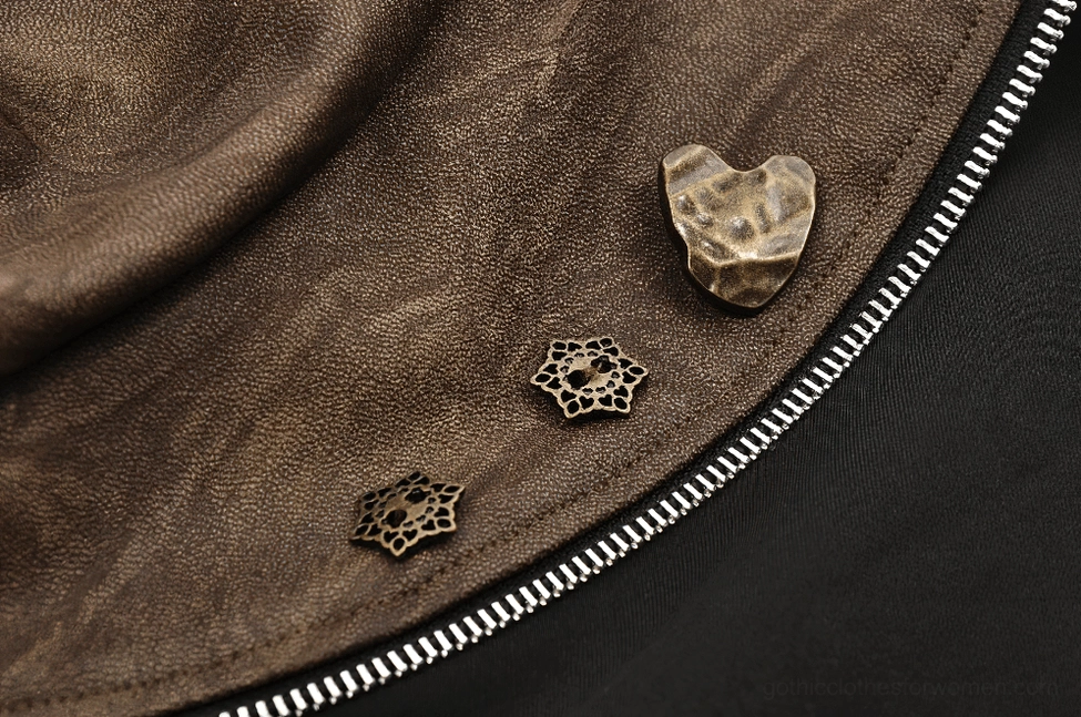 Steampunk bolero hardware macro closeup showing heart and gear-shaped metal brooches with silver exposed zipper