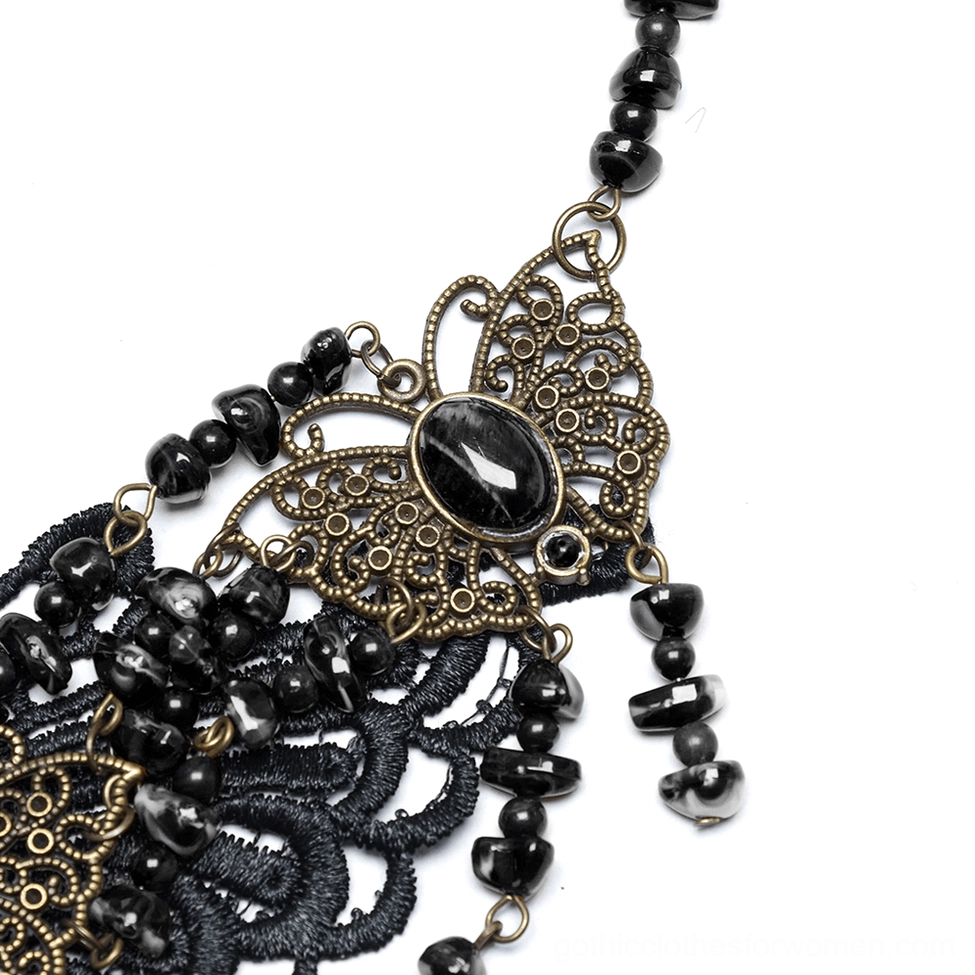 Macro side-angle close-up of bronze filigree butterfly with black beaded tassels hanging detail