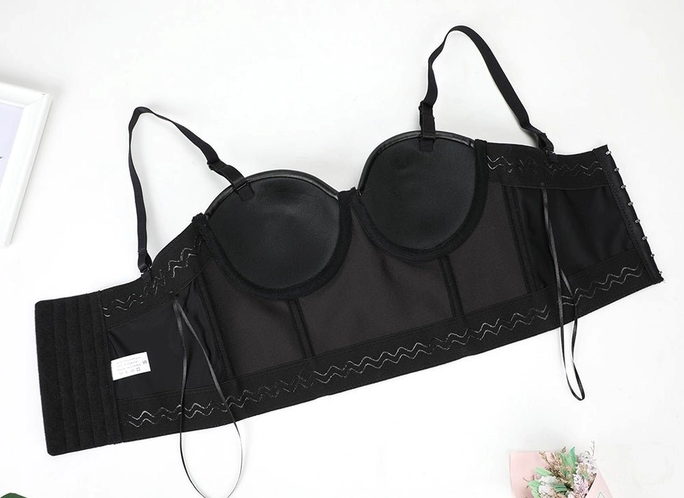 Black synthetic leather corset bra flat lay showcasing mesh back panel and decorative lace-up side design detail