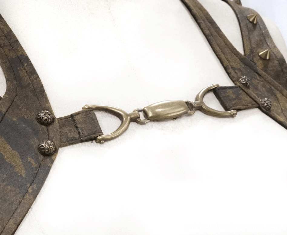 Close-up of steampunk vest strap details showing metal buckles and pyramid rivet embellishments