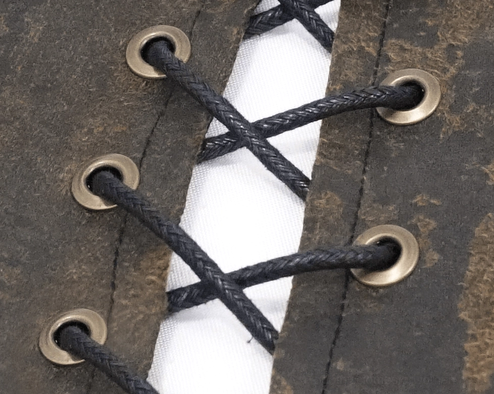 Close-up of front lace-up closure with faux leather and metal eyelets on brown steampunk vest