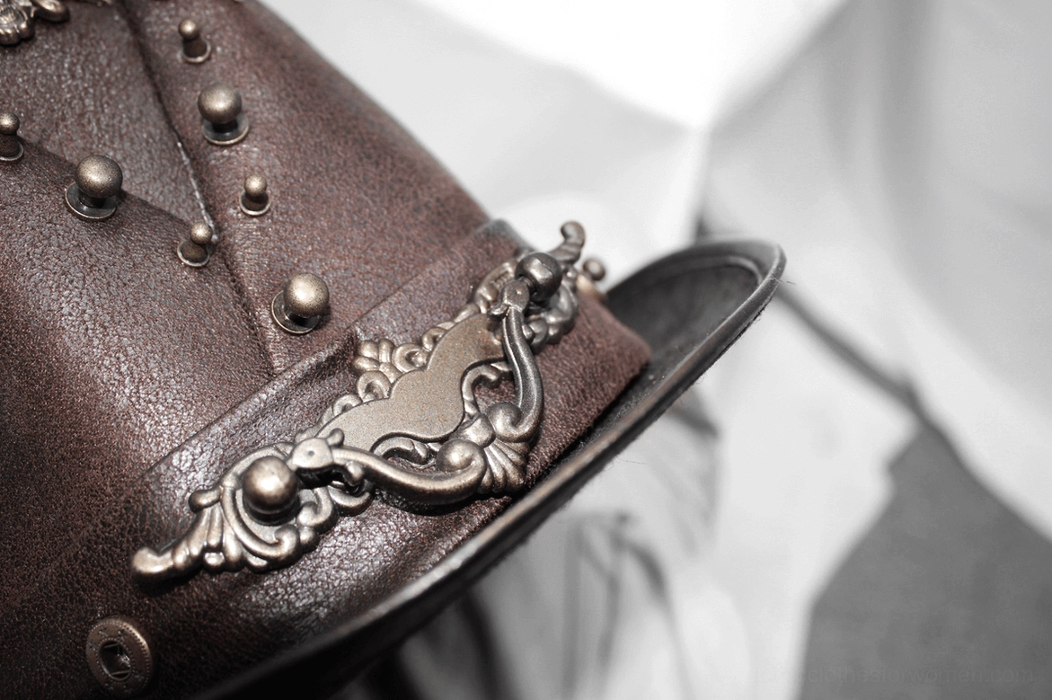 Front-facing display of brown steampunk gothic hat highlighting skull metal ornament, structured brim, and bronze rivet accents
