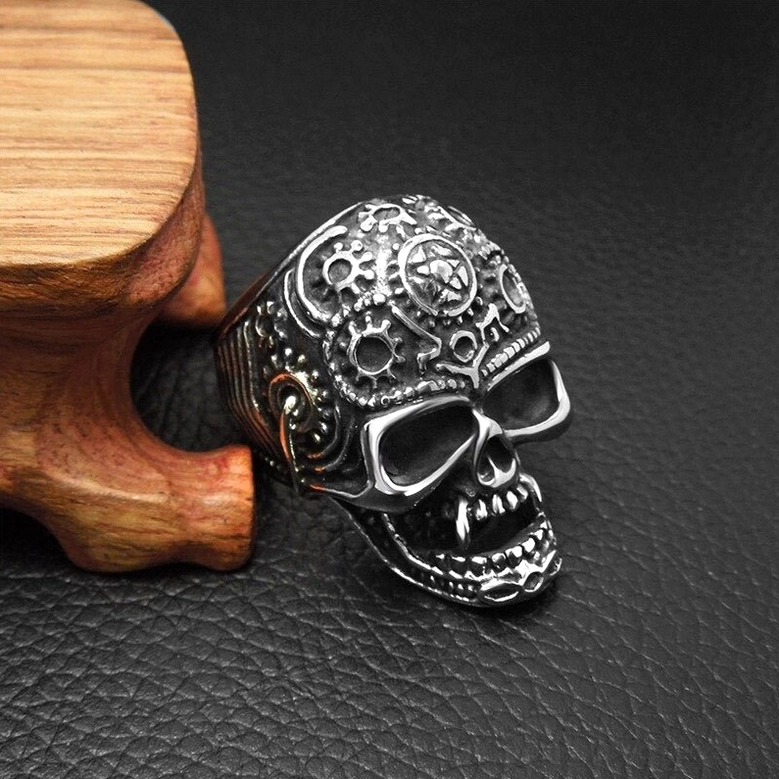 Left side front angle of gothic skull ring showing visible band with mechanical gear carvings and detailed skull centerpiece