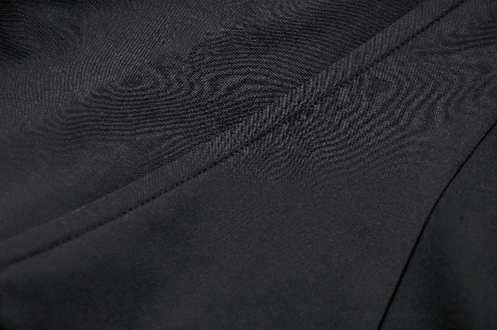 Black hooded cape architectural detail showcasing structured design and premium nylon construction