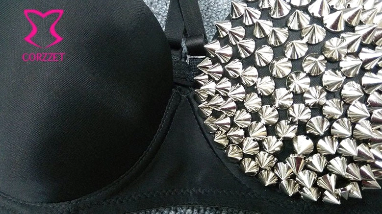 Close-up of dense silver pyramid studs on black fabric, intimate apparel construction detail
