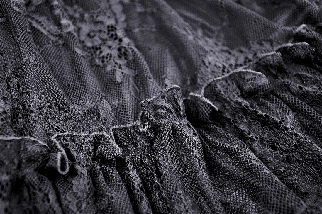 Detail shot of tiered ruffled lace skirt with floral mesh texture on pentagram dress