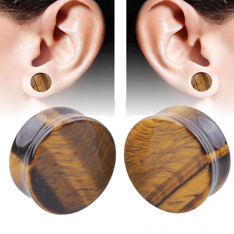 Yellow tigerite stone ear gauges worn on human ear, close-up side view showing how gothic ear plugs sit comfortably in piercing