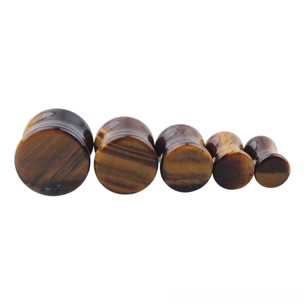 Side profile view of yellow tigerite stone ear plugs arranged by size, displaying the depth and rounded edge design of these gothic body jewelry tunnels