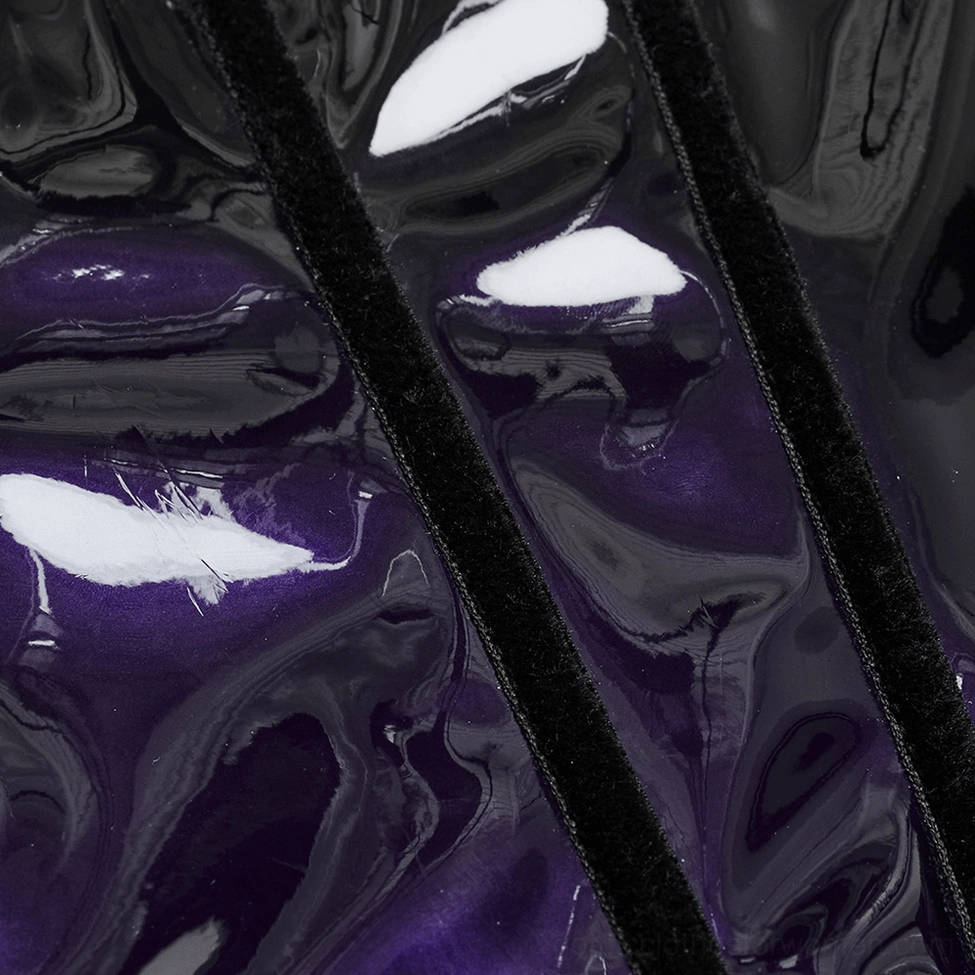 Close-up detail of underbust corset material showing glossy purple-black patent leather texture with soft velvet trim binding