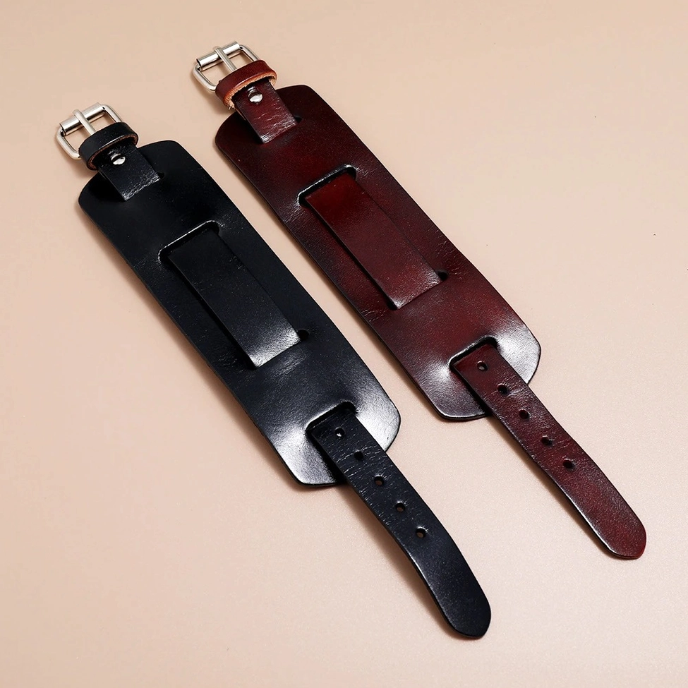 Unfastened black and brown leather cuff bracelets displayed flat, showing adjustable buckle straps and cuff width