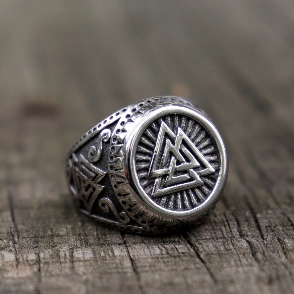 Valknut Norse ring three-quarter front on rustic wood antiqued silver finish weathered surface