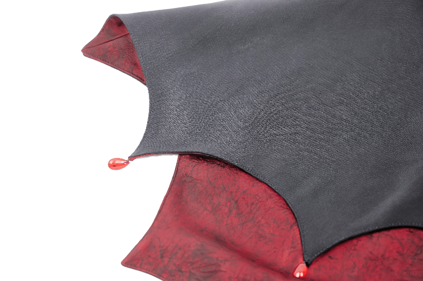 Gothic vampire cape detail shot featuring the jeweled enamel brooch clasp against high standing collar and black outer fabric