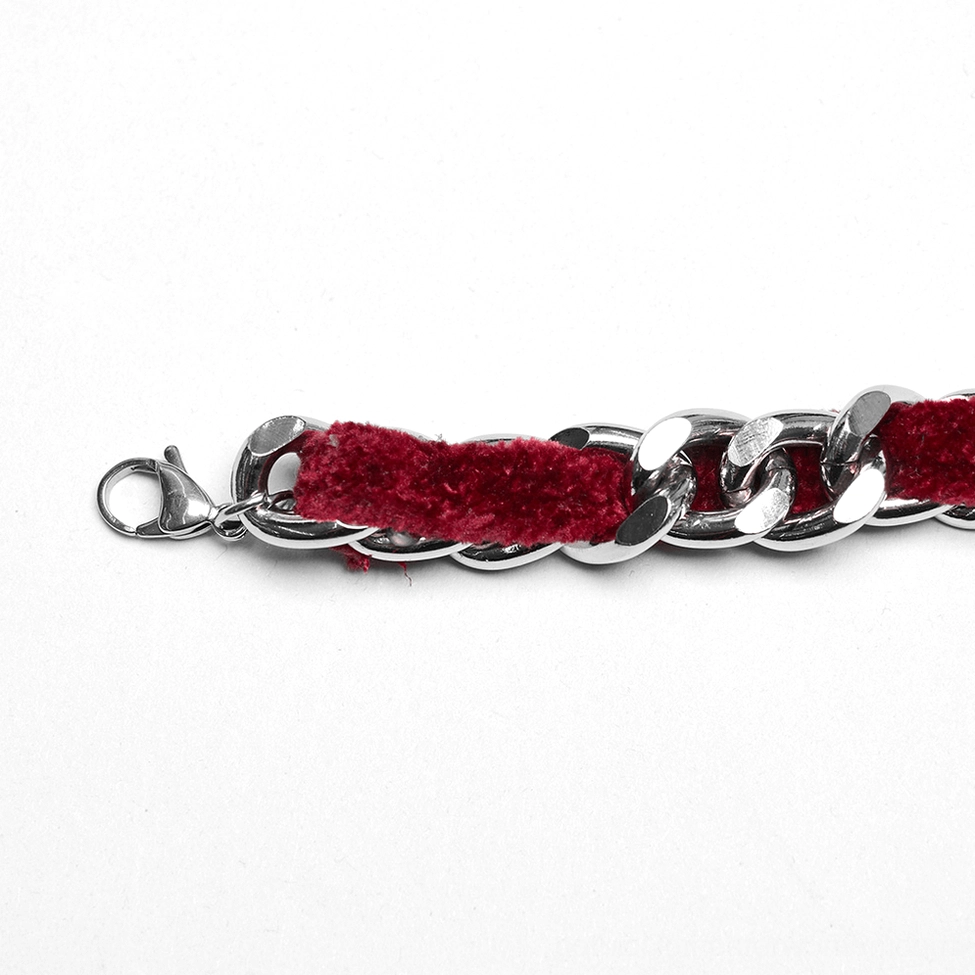 Clasp section of red velvet choker necklace showing stainless steel lobster claw fastening and metal hardware, side flat lay