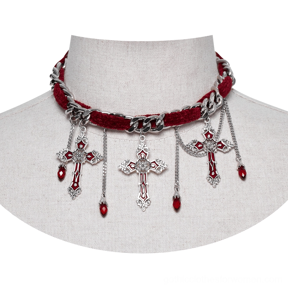 Close-up front view of red velvet gothic cross choker on mannequin, showing silver curb chain and multiple cross pendants with red teardrop charms