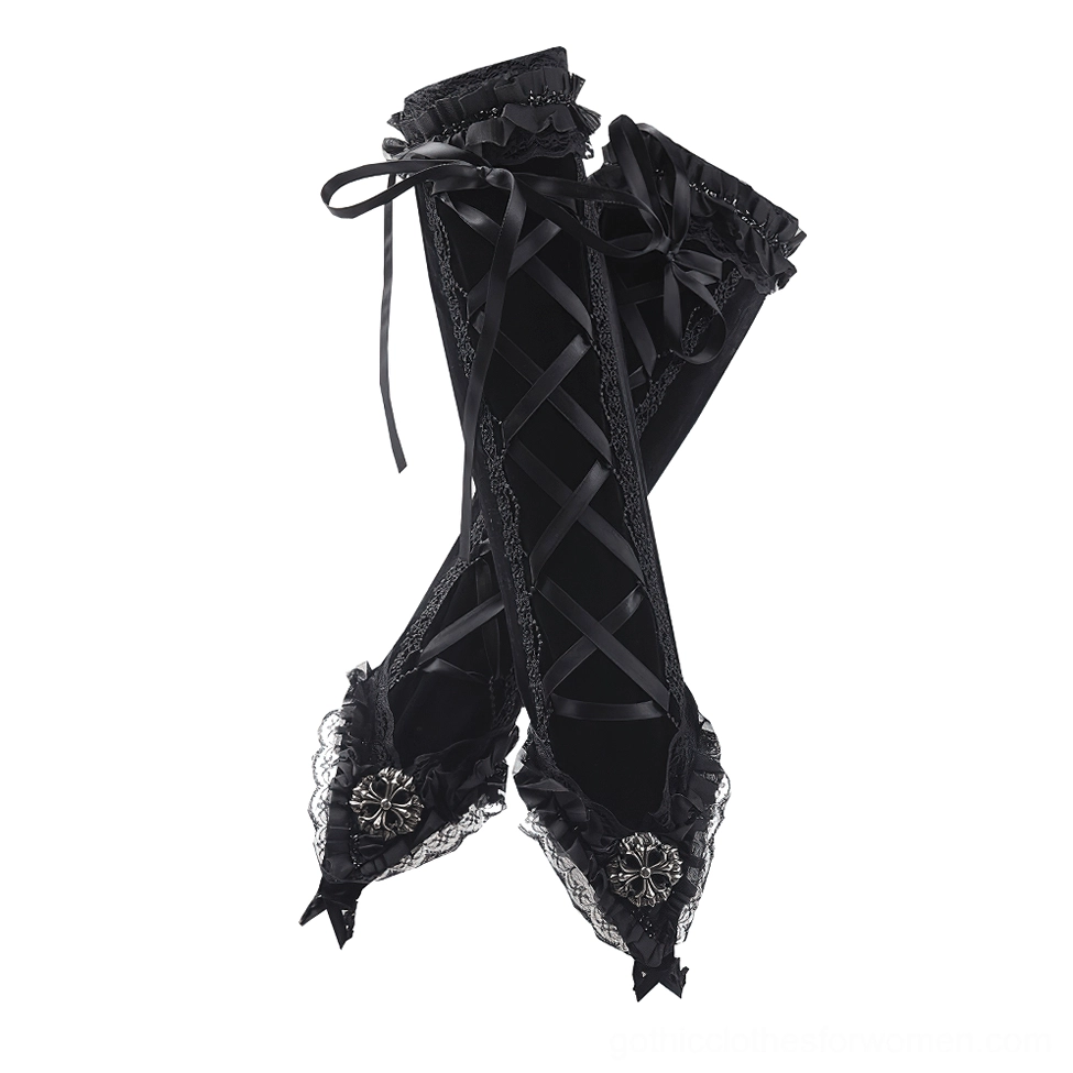 Pair of black velvet fingerless long gloves flat lay, overhead view displaying cross lace-up pattern and decorative metal buckles on cuffs