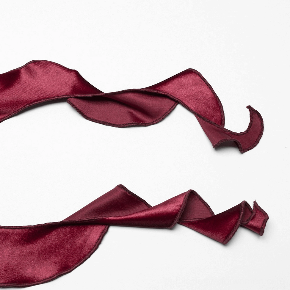 Ruffled hem detail of burgundy velvet gothic long sleeve top showing twisted curved asymmetrical design and ombre dye finish