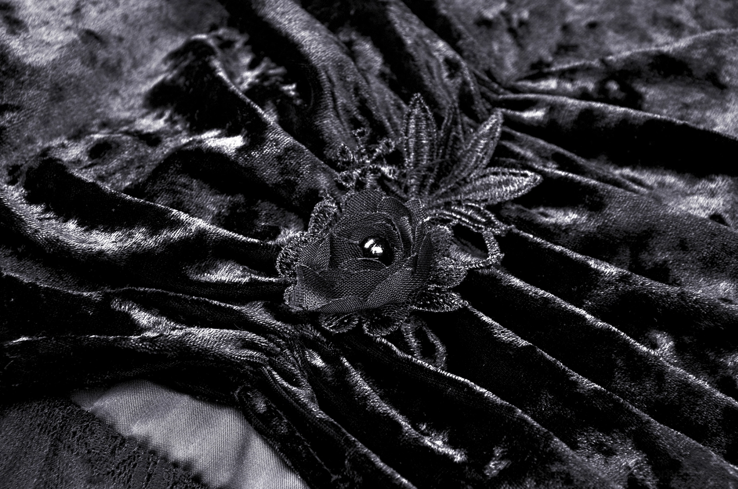 Macro detail of fabric rose applique and gem embellishment on gothic velvet maxi skirt