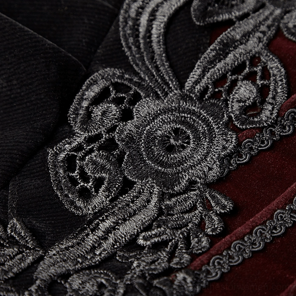 Intricate black floral embroidery detail on velvet tailcoat jacket chest showing lace work and ribbon flower accents