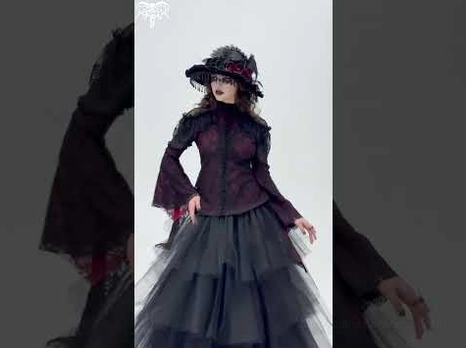 Victorian gothic cold shoulder lace blouse styled with tulle skirt and feathered hat - full body front view in studio setting