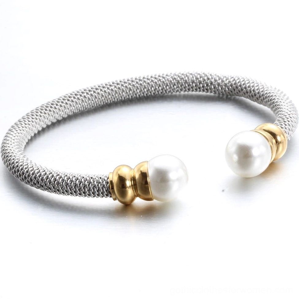 Oblique angle view of victorian-inspired pearl bangle with dual pearl ends and woven stainless steel band