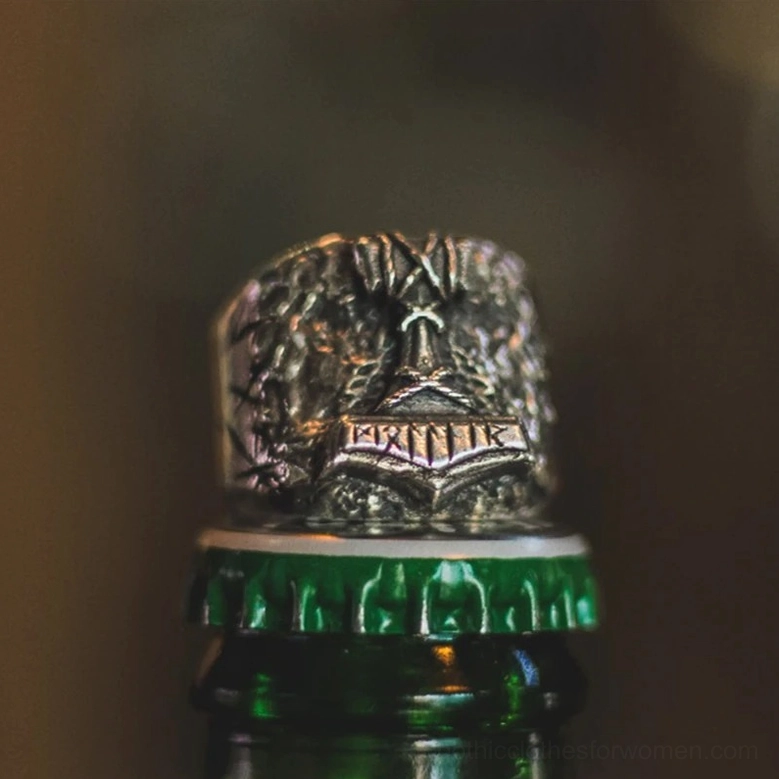 Viking rune ring top frontal view with vintage warm silver tone and intricate carved details on green glass backdrop