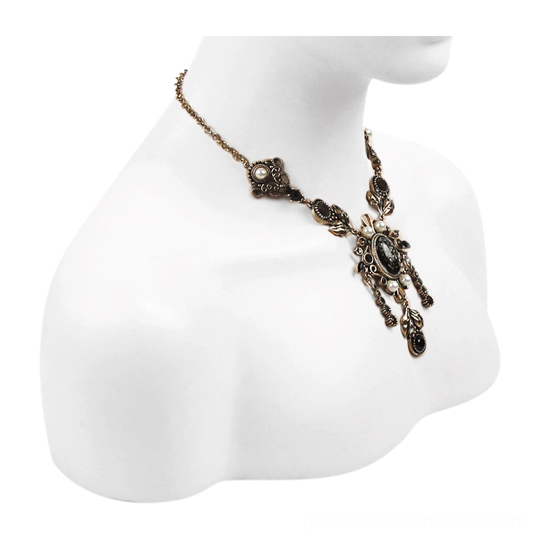 Victorian gothic ornate pendant necklace on bust display, floral metal filigree with embedded gemstones, side-front angle