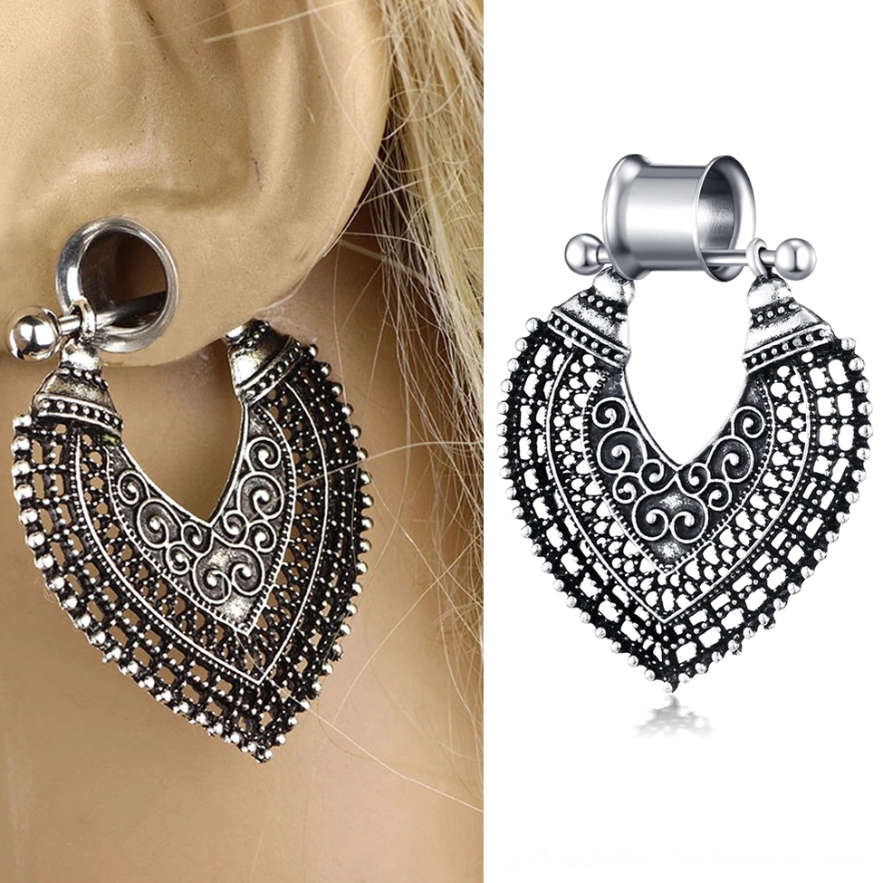 Gothic heart tunnel earring worn on blonde woman's ear showing intricate scroll filigree details in daylight