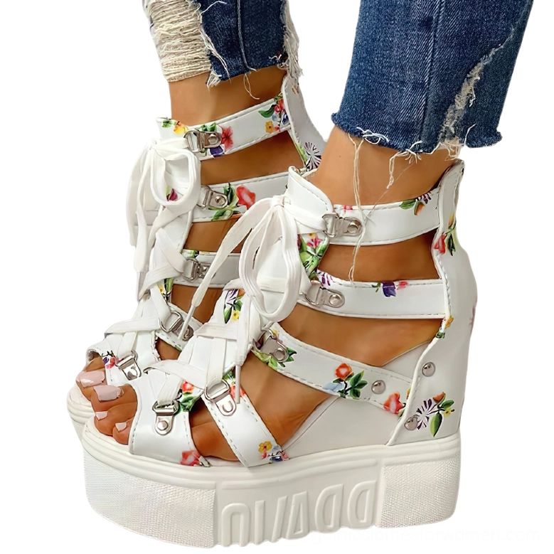 White floral platform wedge sandals with open toe and lace-up buckle closure, displayed on model in studio setting