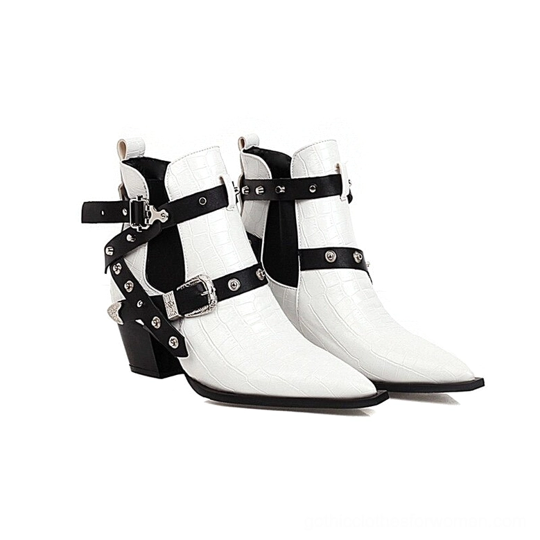 White gothic pointed toe ankle boots with black straps and silver rivets shown in side profile