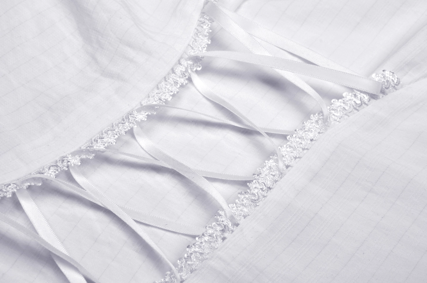 Close-up of white lace-trimmed back corset-style lacing on ivory Victorian gothic blouse