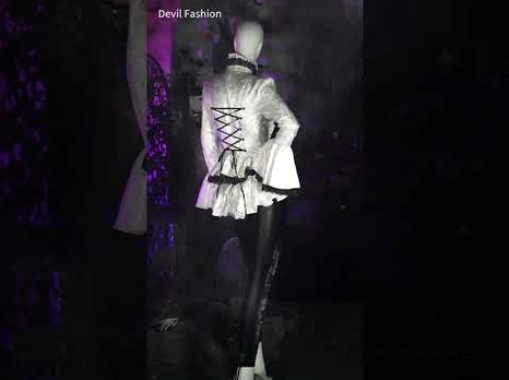 Gothic white blouse mannequin display with dark purple lighting showing lace-up corset back and flared sleeves with gothic aesthetic