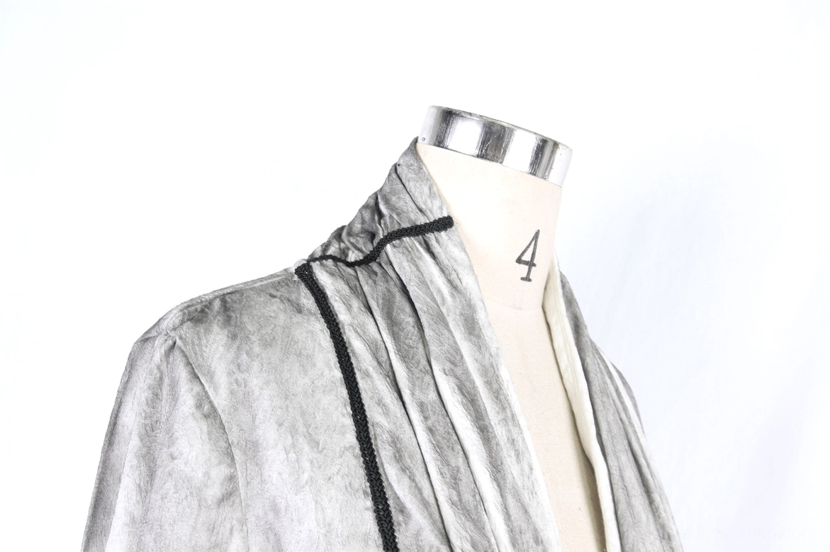 Close-up of white gothic blouse shoulder and collar construction showing tailored black piping