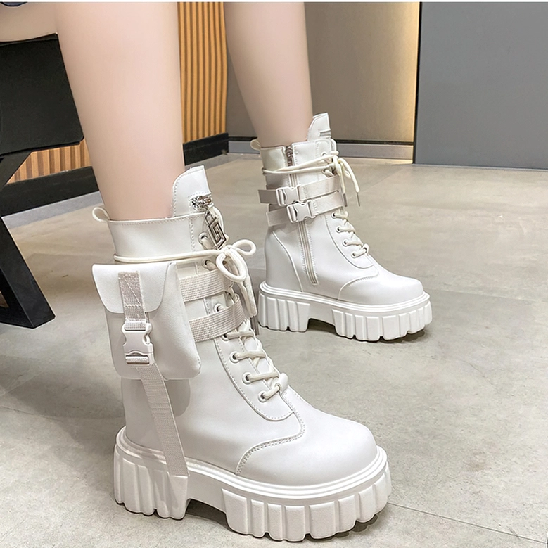 Model wearing white platform lace-up combat boots with lug sole on tiled indoor floor