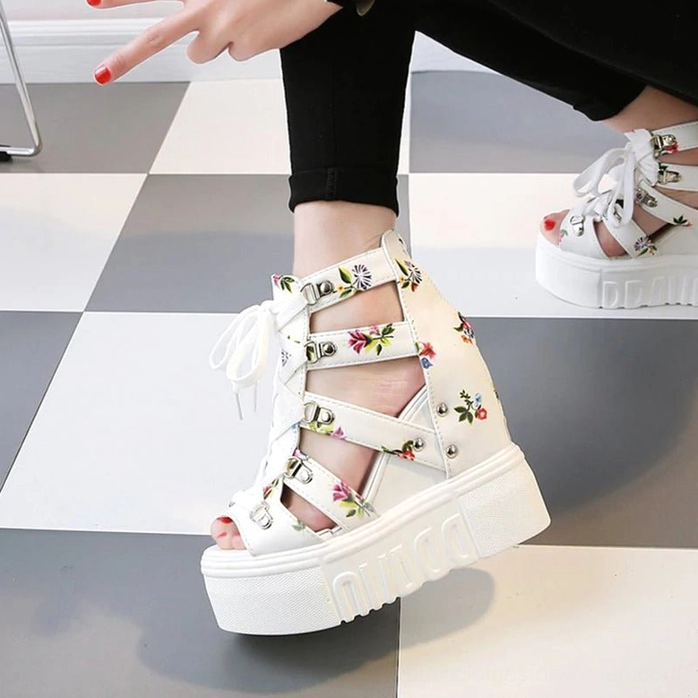 White floral platform wedge sandals with open toe and lace-up closure, worn on checkered tile floor