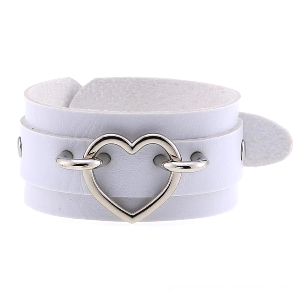 White leather heart cuff bracelet with silver hollow heart detail, ethereal goth aesthetic flat lay view
