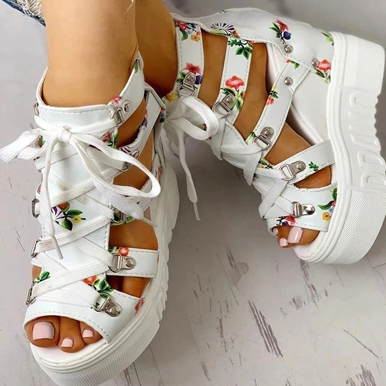 White floral platform wedge sandals with chunky white sole and open toe, bare feet side and top view on wood background