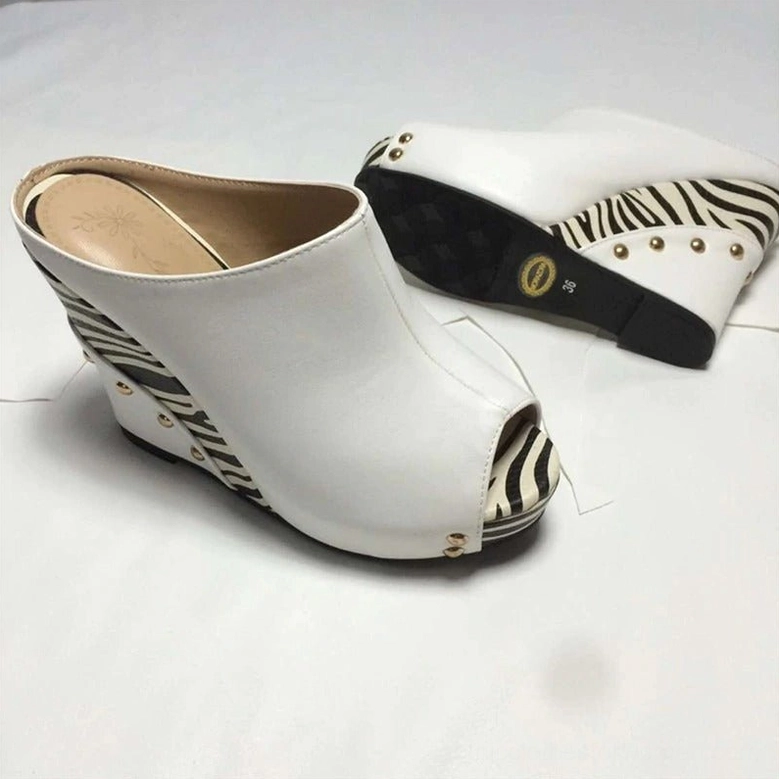 White gothic zebra wedge sandals showing top and side angles with branded outsole and gold rivet accents