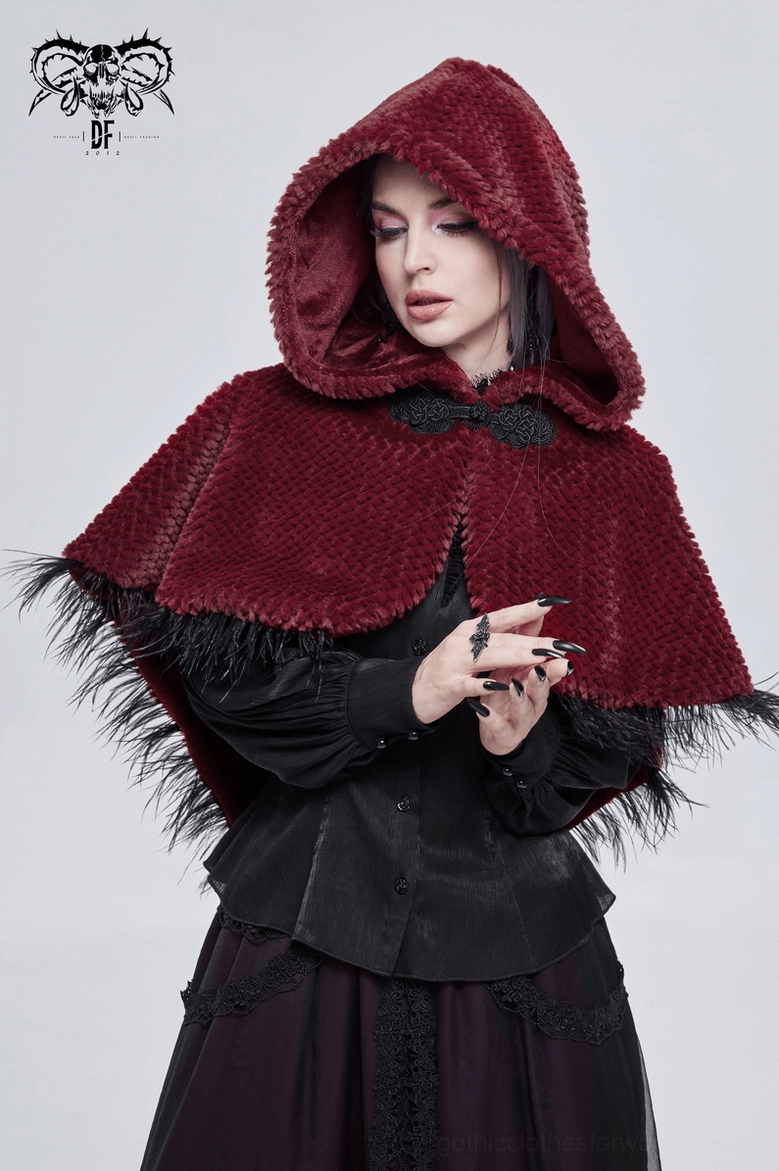 Front view of female model in burgundy hooded gothic cape with hands clasped, showing grainy plush fabric