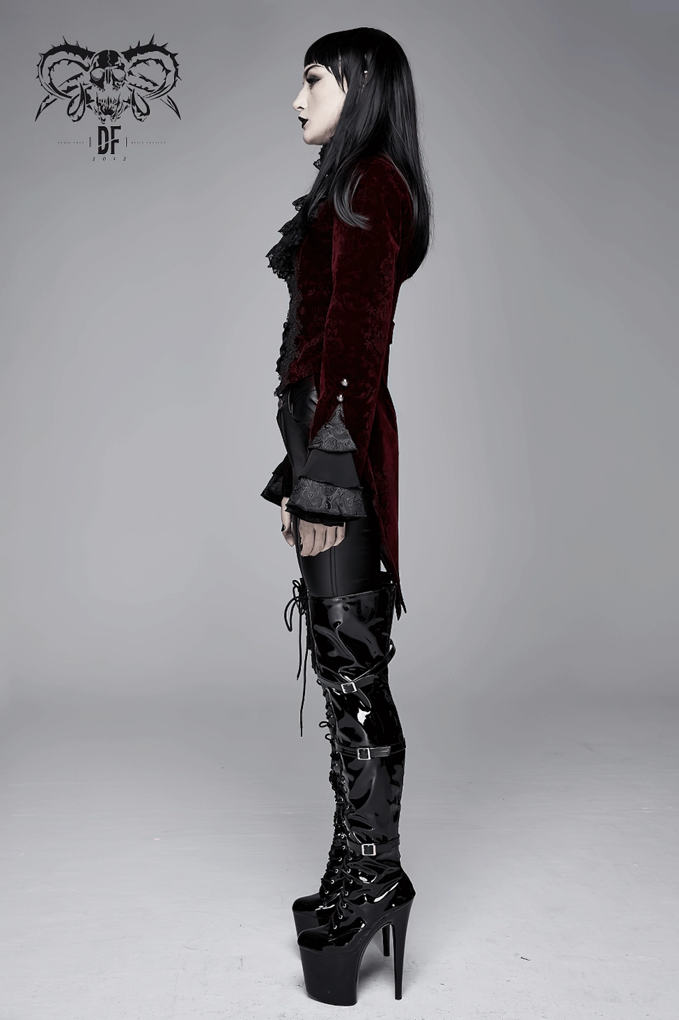Left side profile of gothic velvet tailcoat showing dramatic split tail hemline and layered lace cuffs with tall platform boots