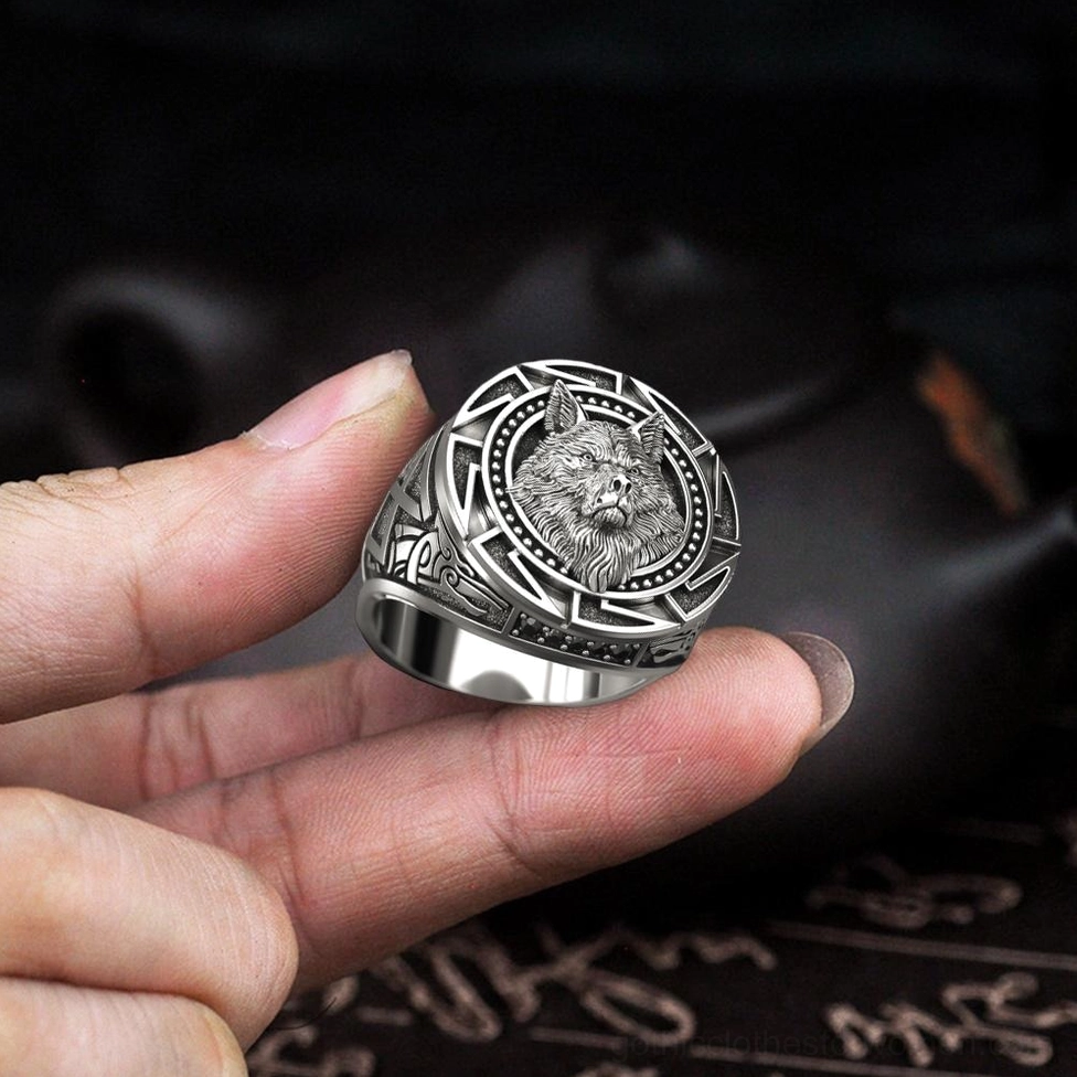 Gothic wolf head ring fingertip holding close-up antique silver finish detail dark background