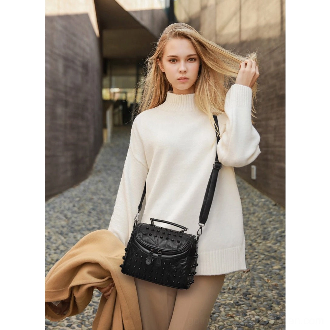 Black studded leather messenger bag for women featuring genuine sheepskin construction and gothic alternative fashion aesthetic