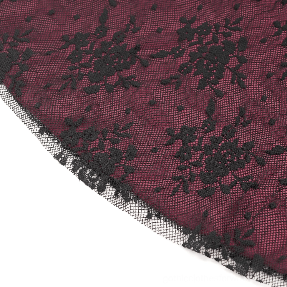 Women's black velvet gothic flare pants with burgundy lace overlays and embroidered appliqué showing close-up of fabric texture