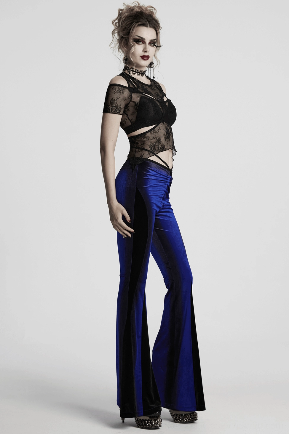 Back full-length view of women's navy velvet gothic pants showing tie closure and flared silhouette