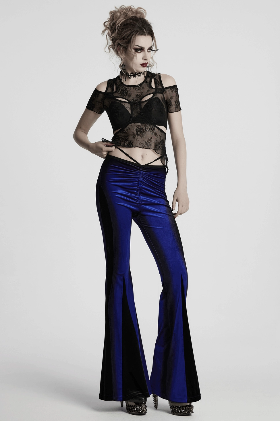 Detail shot of waistband and front ruching on women's navy velvet gothic flare pants