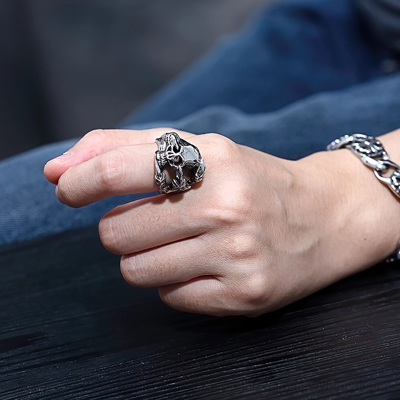 Worn gothic skull ring on male hand with chain bracelet styling paired