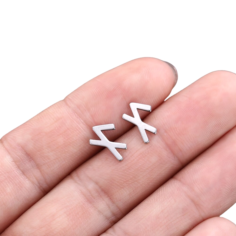 X-shaped gothic rune stud earring in human fingertips, minimalist silver hollow design showcasing bold angular geometry