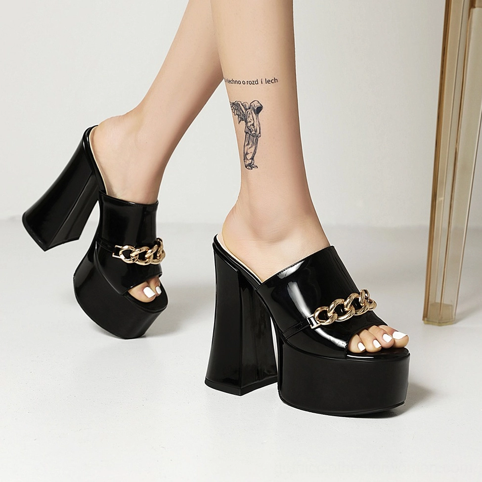 Detailed view of yellow gothic platform mule heels showing glossy patent leather finish and chain embellishment