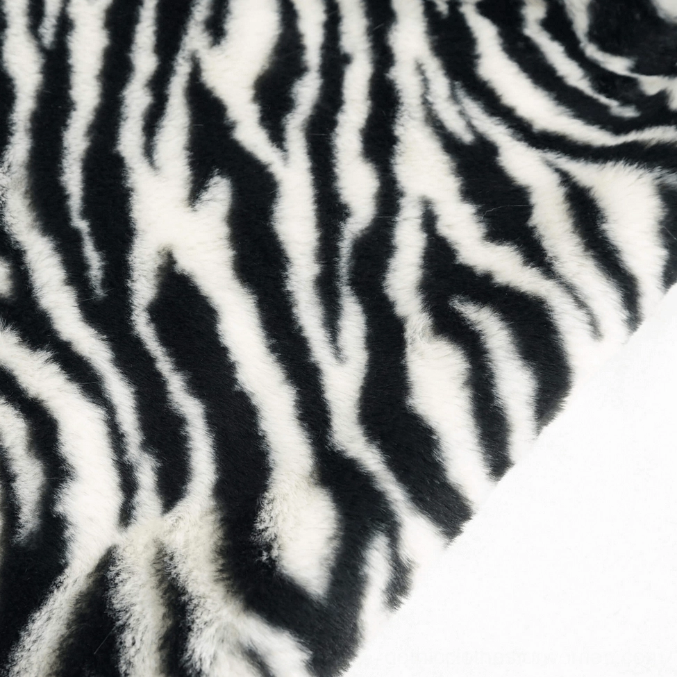 Texture close-up of bold black and white zebra stripe pattern on soft fluffy faux fur fabric of gothic jacket